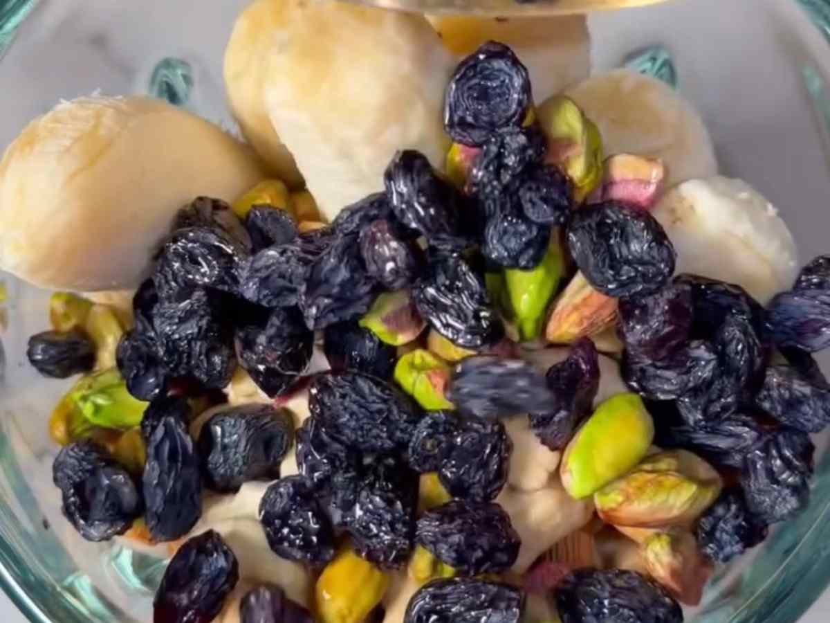 Minha sogra não para um segundo: o segredo do copo que dá energia de guria e disposição pra nos incomodar #129 Passo 2 da Receita de Smoothie - Mel sendo derramado sobre o mix de frutas secas e leite.